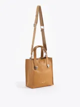 Cartera tipo tote pequeña de cuero color tostado, con doble asa superior y herrajes metálicos plateados en forma de llama en la base de las manijas. Presenta el logo de la marca estampado en la parte inferior frontal.