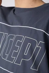 Remera gris oscuro de corte boxy, con mangas cortas y cuello redondo. Cuenta con un diseño gráfico frontal con líneas blancas y la palabra 'CONCEPT' estampada.