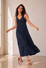 Vestido largo de lino azul marino, sin mangas, con escote en V y corte en la cintura. Presenta costuras pespunteadas a la vista y falda amplia con vuelo.