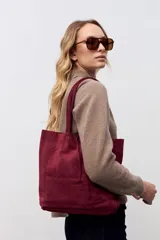 Bolso tipo tote de gamuza en color bordó, con diseño minimalista, costuras verticales decorativas y doble asa de hombro.