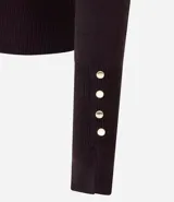 Suéter de punto ajustado con cuello redondo y manga larga. Presenta detalle de botones metalizados en los puños.