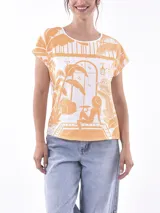 Remera de manga corta, cuello redondo, color blanco con estampado en azul que simula una escena tropical vista desde un interior, con plantas y una figura sentada.