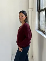 Saco tipo cardigan de punto, color bordó, con escote en V y cierre frontal de botones. Presenta mangas largas con puños acanalados y un diseño de calce holgado.