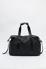 Bolso tipo duffel negro de símil cuero con cierre superior de cremallera metálica y asas reforzadas.