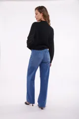 Pantalón de jean azul medio, corte wide leg, con bolsillos delanteros tipo parche y tiro alto.