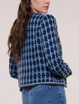 Chaqueta corta de corte estructurado confeccionada en tejido de tweed azul con patrón de cuadros, escote redondo sin solapa, frente abierto, bolsillos falsos y ribetes trenzados con hilos metalizados.