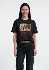 Remera blanca de manga corta con cuello redondo y estampado frontal tipo cuadro con texto decorativo en azul.