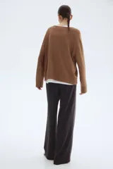 Pantalón de tejido de punto pesado color gris oscuro, tiro alto con elástico oculto en la cintura y piernas rectas con pliegues marcados.