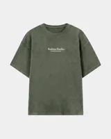 Remera oversize negra con diseño gráfico en la espalda que incluye la inscripción "Kaboa Radio" y un personaje ilustrado, de corte amplio y mangas cortas.