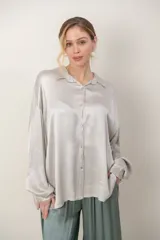 Camisa de satén tramada, de calce holgado y diseño cómodo con mangas largas.