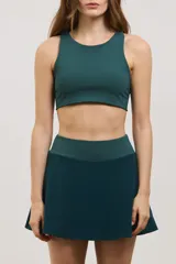 Top deportivo de sujeción media con escote redondo, diseño al cuerpo y espalda abierta. Confeccionado en tejido elastizado con elástico interno en la cintura.