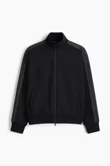 Campera deportiva negra de tejido funcional efecto neopreno con tecnología DryMove. Presenta cuello elevado, cierre bidireccional, bolsillos laterales y franjas grises en las mangas.