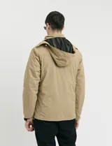Campera 2 en 1 color beige, con cuerpo y capucha desmontable, manga larga, cierre frontal con botones a presión y bolsillos laterales engomados.