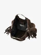 Cartera de mano confeccionada en cuero gamuzado color marrón, con diseño flexible y detalles de flecos laterales. Presenta un asa rígida metálica circular y una abertura superior fruncida.