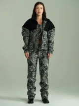 Campera estilo trucker de denim texturado con estampa gris y negra, con canesú superior liso en negro, cuello de piel sintética negra y cierre frontal con botones a presión.