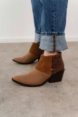 Bota corta de cuero color marrón con paneles de gamuza y cuero texturizado.