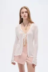 Saco abierto de viscosa color blanco, con cuello en V, lazo para anudar al frente y mangas largas con terminación ondulada.