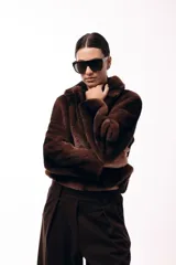 Tapado corto de piel sintética en color marrón chocolate, con cuello solapa amplio y cierre frontal oculto. Presenta una silueta estructurada y elegante.