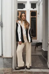 Campera con capucha, de tela tipo peluche a rayas verticales color marrón y blanco, con ribete color beige.