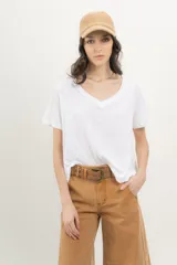 Remera blanca de algodón orgánico, manga corta y escote en V con fit A-line. Detalle de cinta aplicada en la espalda con bordado de palmera.
