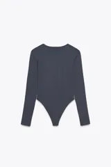 Body de manga larga confeccionado en mezcla de poliamida, con cuello redondo y cierre inferior con botones a presión.