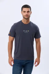 Remera de manga corta color azul oscuro, con cuello redondo y detalle de bordado pequeño en el centro del pecho que representa tres figuras geométricas con forma de árboles y el texto Legacy Brand.