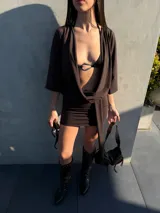Vestido corto marrón con escote pronunciado en V, mangas murciélago y faja integrada para atar en la cintura.