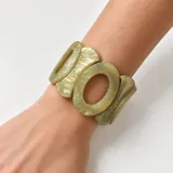 Pulsera elástica de resina color verde con diseño de piezas ovaladas entrelazadas.