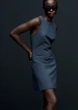 Vestido corto de corte evasé con estampado de raya diplomática. Presenta cuello redondo, diseño sin mangas y dos bolsillos de ribete en la parte delantera. Incluye cierre de cremallera invisible y botón en la parte posterior.