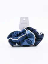 Set de tres scrunchies (coleteros) para el cabello. Dos son de tela denim azul en tonos contrastantes y uno parece ser de tela lisa azul oscuro. Todos tienen un borde de ribete color beige claro.