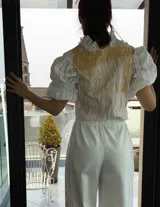 Remera blanca de algodón con estampado color cobre y mangas de broderie negro con elástico.