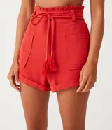 Short clochard de viscolino color beige, con cintura alta elastizada, bolsillos grandes aplicados en los laterales y detalle de cinturón de cuerda con borla.
