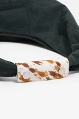 Bolso de hombro tipo shopper de nylon color verde oscuro, con estructura blanda y asa de piel. Presenta un asa superior con detalle de pelo sintético estampado (efecto vaca/marrón y blanco) y cierre de botón de presión. Lleva el logo metálico BIMBA Y LOLA en la parte inferior frontal.