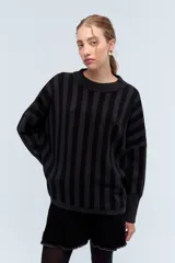 Sweater de punto a rayas verticales en tonos negro y gris oscuro, de corte holgado y cuello redondo.