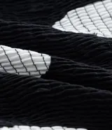 Vestido midi de algodón con estampado de lunares blancos sobre fondo negro. Presenta escote en V, mangas cortas abullonadas, cintura ajustada con cinturón de hebilla y falda con tajo lateral.