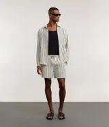 Bermuda de playa Marfinno para hombre, con diseño de rayas verticales en tonos blanco y negro, confeccionada en poliéster texturizado. Cuenta con cintura elástica con lazo ajustable y bolsillos laterales.