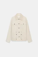 Chaqueta estilo safari color beige, con cuello de solapa tejido en crochet, manga larga, bolsillos delanteros con solapa y cintura ajustable con cordones. Cierre frontal con botones metálicos a presión.