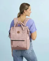 Mochila Cabaia modelo Adventurer, color rosado con acabado texturizado. Cuenta con un compartimento principal con cierre, un bolsillo frontal con cierre, asas superiores de mano y correas ajustables. Incluye parches decorativos con el logo de la marca.