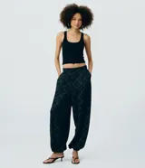 Pantalón aladín de viscosa negro con estampado de cuadros y diseño abombachado con puños ajustados en los tobillos.
