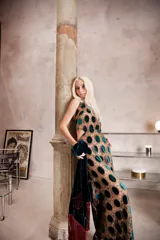 Vestido largo de encaje con diseño de círculos de terciopelo verde, con escote halter que se ata en la nuca y espalda descubierta con ajuste en la cintura.