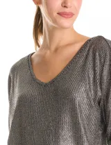 Blusa de tejido acanalado con acabado metalizado, escote en V y mangas tres cuartos estilo japonés. Presenta un diseño holgado con costura central en la espalda y ruedo curvo.