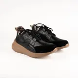 Championes deportivos de cuero en tonos marrón, tostado y marrón oscuro, con detalles de estampado animal print de leopardo en el lateral, suela gruesa blanca y cordones elásticos.