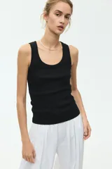Musculosa entallada confeccionada en punto de algodón acanalado, con escote redondo y diseño sin mangas.