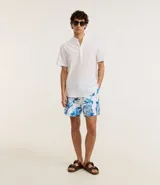 Bermuda de baño masculina en microfibra blanca con estampado de caracolas en tonos azules. Cuenta con cintura elástica ajustable con cordón y bolsillos laterales.