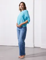 Blusa de gasa con estampado geométrico en tonos negro, gris y celeste. Tiene cuello redondo y mangas 3/4 amplias con abertura y botón.