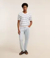 Pantalón de jeans celeste, corte slim, con bolsillos delanteros y traseros, trabillas en la cintura y cierre tradicional con botón y cremallera.