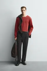 Camiseta de manga larga con cuello redondo, corte relajado y diseño de rayas horizontales en tonos rojo y negro.