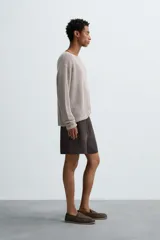 Jersey de punto calado confeccionado en hilatura de cáñamo, con un diseño de calce relajado, cuello amplio y manga larga.