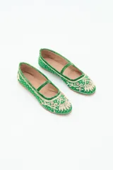 Bailarina negra de estilo plano con tira de terciopelo que cruza el empeine. Presenta bordados intrincados en hilo dorado y apliques de lentejuelas y cuentas en la punta y el cuerpo del zapato.