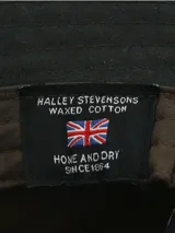 Gorro tipo bucket negro confeccionado en canvas engrasado inglés resistente al agua, con forro interior de algodón orgánico.